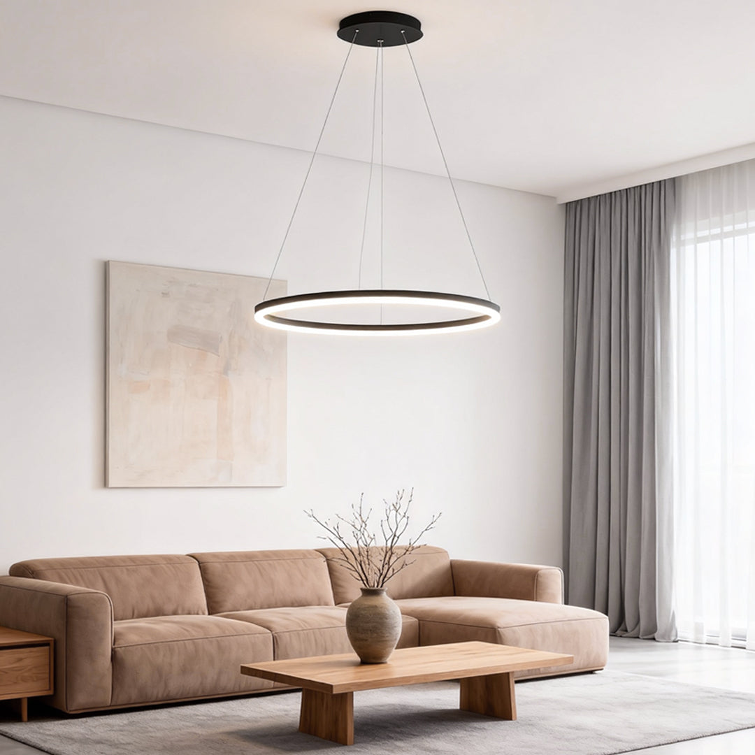 Black LED ring chandelier hanging in a cozy living room with beige sofa and curtains.