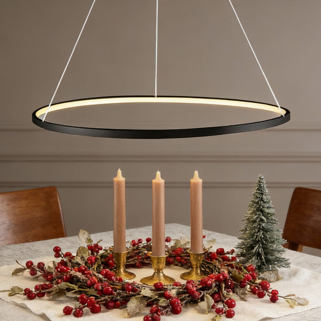 Black LED ring chandelier hanging above dining table with minimalist holiday decor.