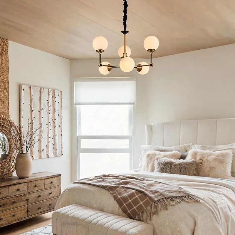 Glass ball chandelier modern hanging in a bedroom with soft globe lights and minimalist decor.