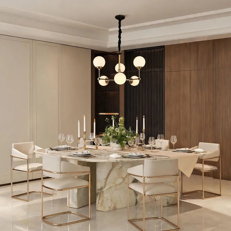 Glass ball chandelier modern installed above a dining table with elegant black and gold accents.