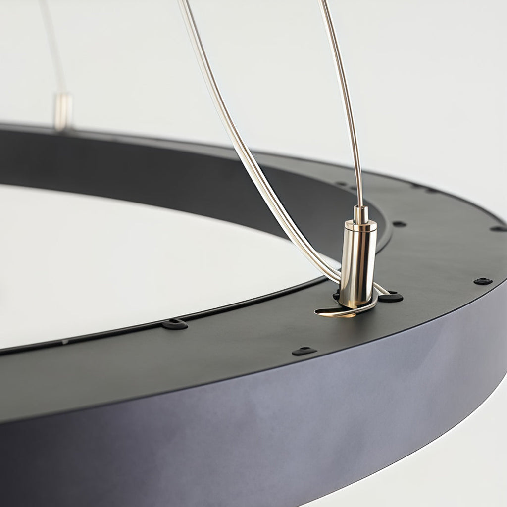 Detailed view of oval chandelier cable connection and ceiling suspension system.
