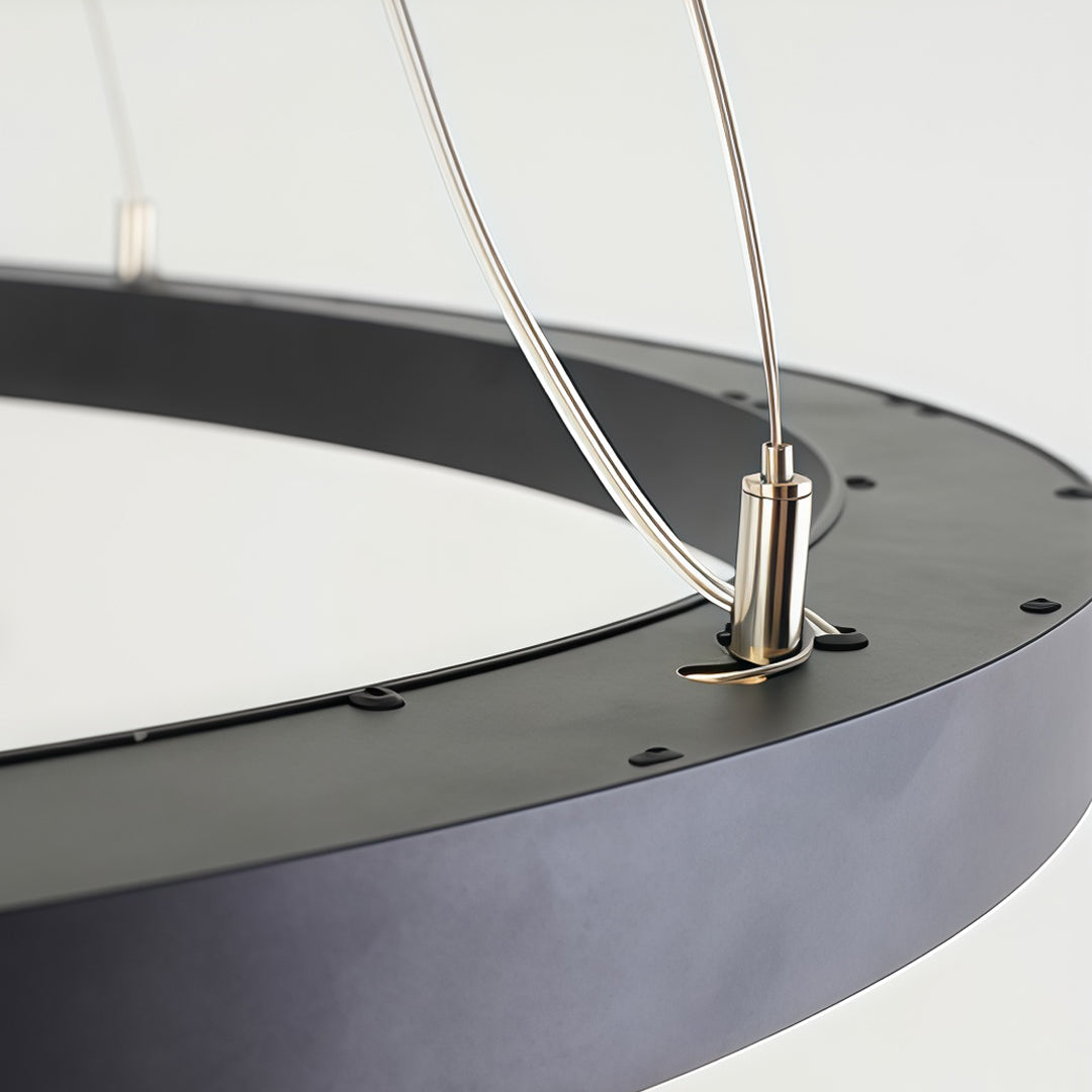 Detailed view of oval chandelier cable connection and ceiling suspension system.
